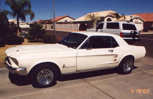 White Ford Mustang hardtop coupe, passenger side view in a driveway