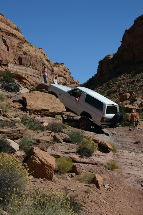 1993 Ford Bronco - White 1993 Ford Bronco tackles a challenging off-road course in a desert canyon.