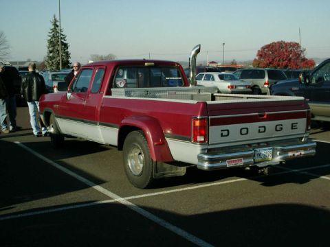 2002 Ford F-250 - This Dodge pickup truck features a prominent tall exhaust pipe and a two-tone red and silver paint scheme.
