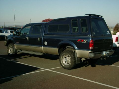 2002 Ford F-250 - This 2002 Ford F-250 Super Duty pickup truck is equipped with a blue camper shell and has 4x4 off-road badging.