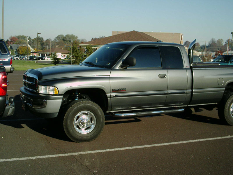 Silver Dodge Ram quad cab diesel pickup side view with chrome exhaust stack