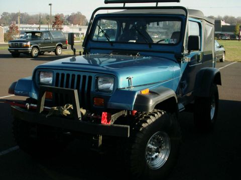 2002 Ford F-250 - A blue Jeep Wrangler is parked in a lot, with another SUV visible in the background.