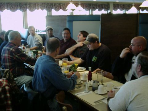2002 Ford F-250 - A group of men are seated at tables in a diner, engaged in conversation.