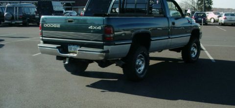 2002 Ford F-250 - This Dodge pickup truck, likely from the mid-1990s, is shown from the rear in a parking lot.