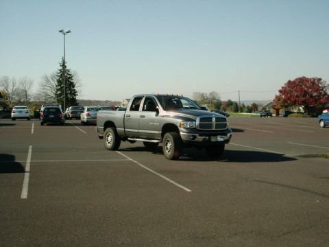2002 Ford F-250 - A silver Dodge Ram 2500 pickup truck is parked in a lot on a sunny day.