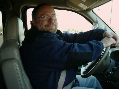 2002 Ford F-250 - Man driving a truck interior. Watermark reads SUPERMOTORS.