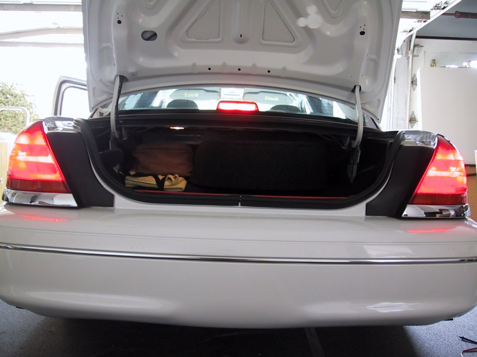2003 Ford Crown Victoria trunk open, showing luggage and spare tire