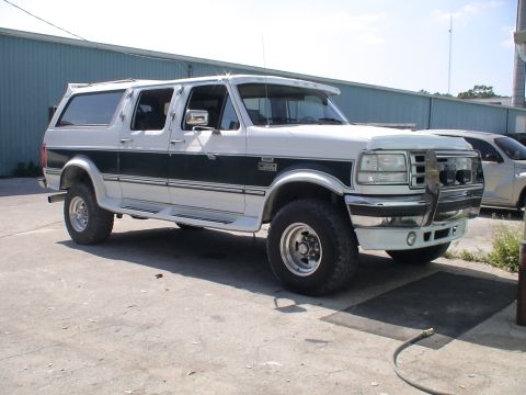 1993 Ford C-350 (Centurion Conversions) - White 1993 Ford C-350 Centurion Conversion SUV with a dark green stripe and custom grille guard.