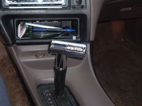 1994 Ford Thunderbird - Interior view of a car's center console showing an aftermarket shift knob and radio.