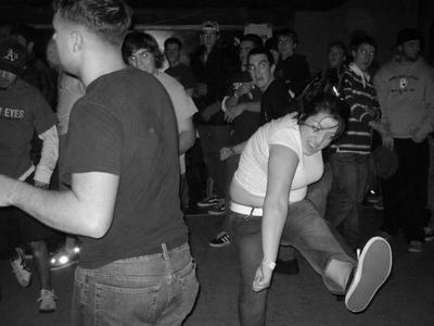 1991 Ford Bronco - A group of people are captured in motion at an indoor event, with one woman in the foreground kicking her leg.