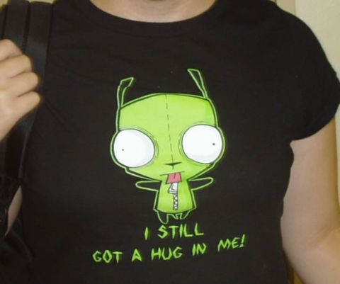 1993 Ford Taurus - A black t-shirt features a green cartoon character with large eyes and a zipper on its chest, accompanied by the text "I STILL GOT A HUG IN…
