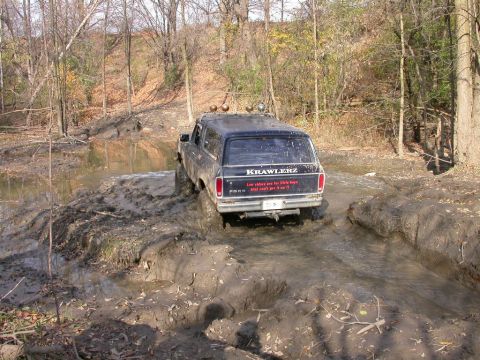 Ford Bronco driving through mud and water, with 'KRAWLERZ' and a quote on the back