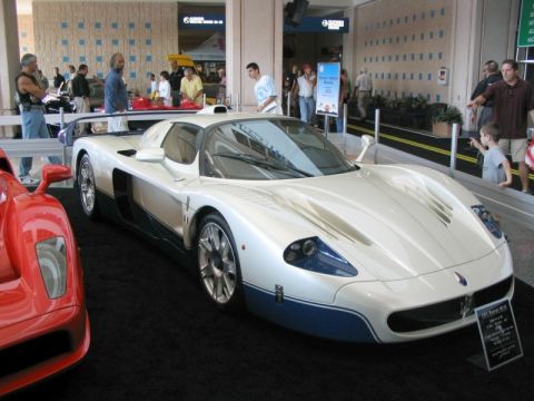 1997 Ford Probe - A white and blue sports car is displayed indoors, with a red sports car partially visible on the left.
