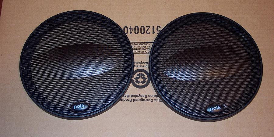 Two Polk audio speakers with black grilles and oval Polk logos