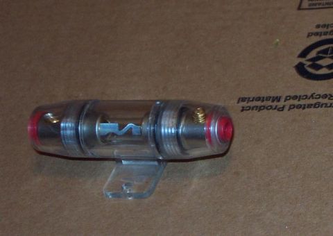 1985 Ford LTD Crown Victoria - A clear inline fuse holder with red end caps is shown against a brown background.