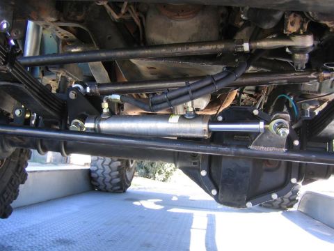1994 Ford Bronco - Close-up view of the steering system and suspension components on a vehicle's undercarriage.