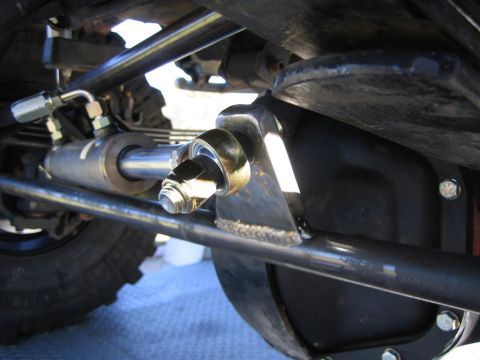 1994 Ford Bronco - Underside view of a vehicle's steering linkage with a power steering assist cylinder.