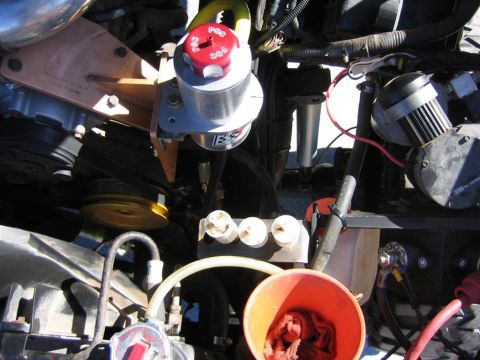 1994 Ford Bronco - Close-up view of engine components, including a power steering reservoir and various hoses and wires.
