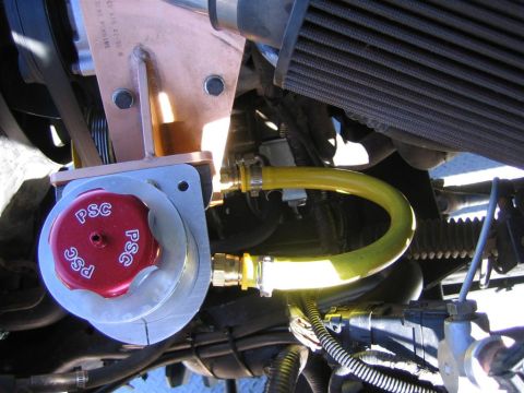 1994 Ford Bronco - Close-up of a PSC power steering pump assembly with yellow hoses and engine parts visible.