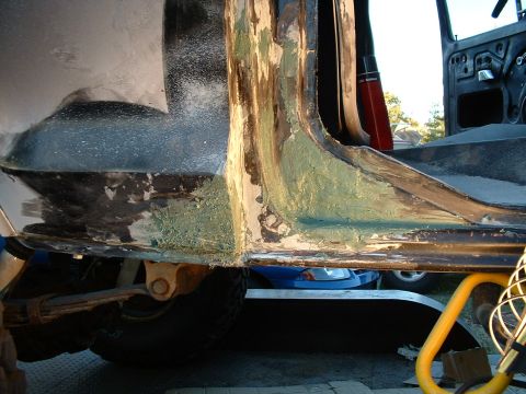 1978 Ford Bronco - Vehicle body panel undergoing repair, revealing rust and filler work.