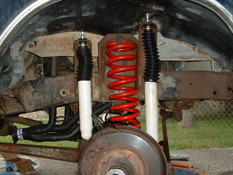 Close-up of red coil springs and white shock absorbers on a vehicle's suspension