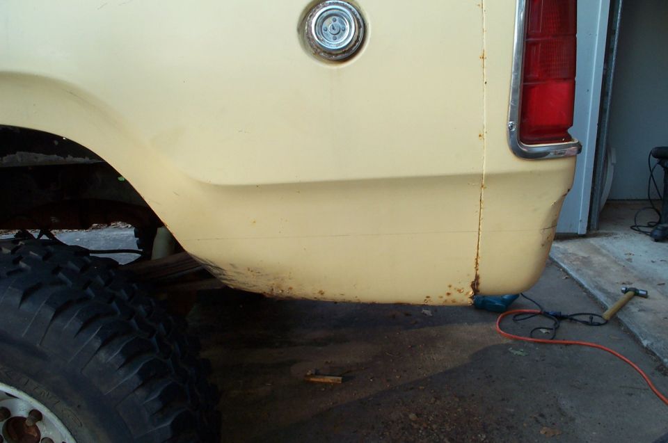 1978 Dodge Power Ram rear quarter panel with rust near the bottom and a fuel filler cap