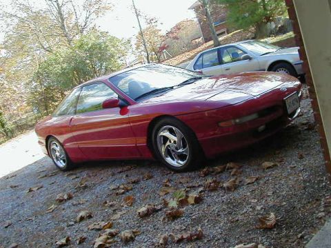 1994 Ford Probe - A red 1994 Ford Probe is parked on a gravel driveway next to a silver sedan.