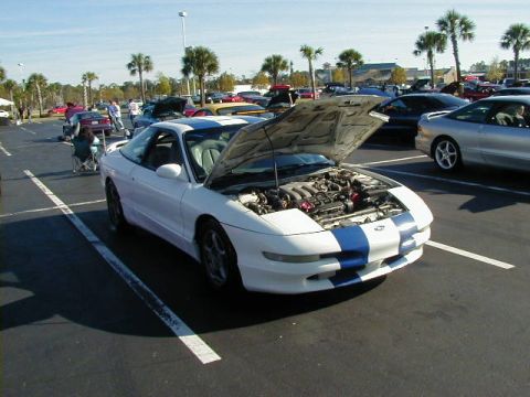 1994 Ford Probe - White 1994 Ford Probe with blue racing stripes, engine exposed, parked at a car show.