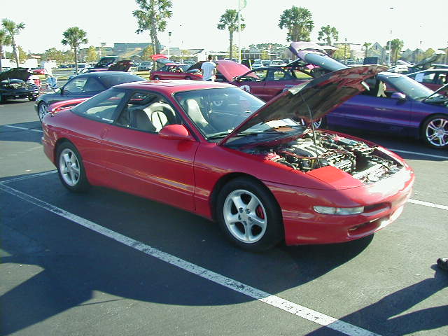 Red 1994 Ford Probe with hood open, parked in a lot
