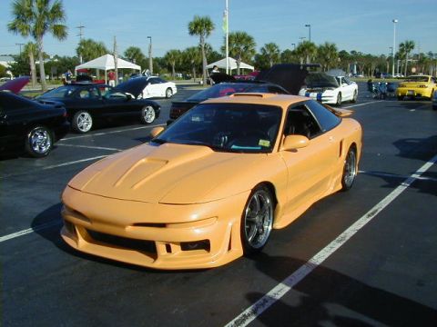 1994 Ford Probe - Customized 1994 Ford Probe at a car meet, surrounded by other vehicles under a clear sky.