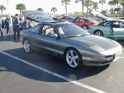 1994 Ford Probe - A gray 1994 Ford Probe GT is parked with its trunk and hood open, showing other vehicles in the background.