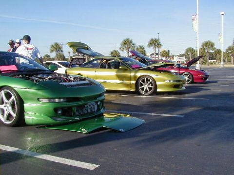 1994 Ford Probe - Several Ford Probes are lined up in a parking lot, some with hoods and trunks open.