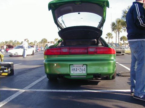 1994 Ford Probe - A green 1994 Ford Probe is shown from the rear with its trunk open, parked at an outdoor event.