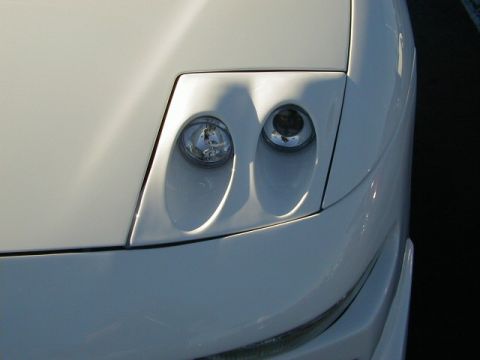 1994 Ford Probe - Close-up of the distinctive dual headlights on a white 1994 Ford Probe.