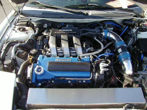 1994 Ford Probe - Engine bay of a Mazda vehicle, blue valve covers and custom intake.