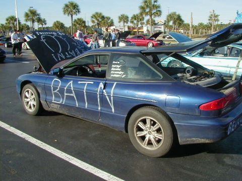 1994 Ford Probe - A blue coupe with 'BATN' written in white on its side and hood, parked in a lot with other vehicles.