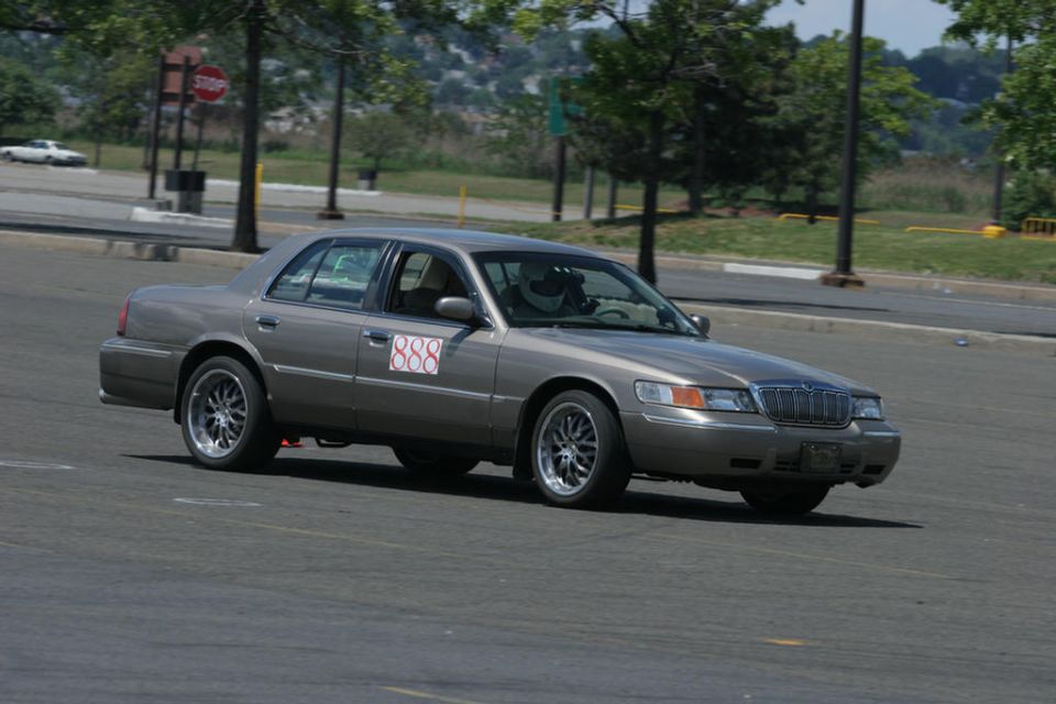 Gold Mercury Grand Marquis sedan with #888 door numbers on an autocross course