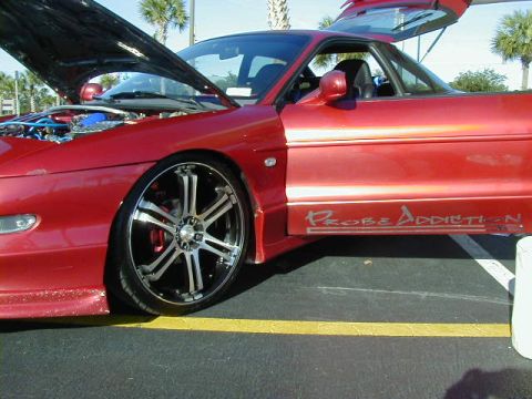 1994 Ford Probe - A red coupe with custom wheels and the "Probe Addiction" decal is shown with its hood and trunk open.