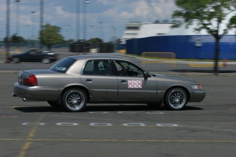 2001 Mercury Grand Marquis - A 2001 Mercury Grand Marquis competes in an autocross event, displaying prominent racing numbers on its side.