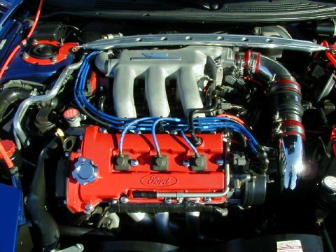 1994 Ford Probe - Engine bay of a 1994 Ford Probe, red valve covers and blue spark plug wires.