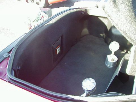 1994 Ford Probe - The trunk of a car features a custom JBL speaker enclosure and decorative piston accents.
