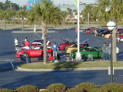 1994 Ford Probe - A gathering of sports cars, including a 1994 Ford Probe, in a parking lot on a sunny day.