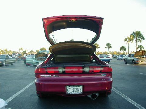 1994 Ford Probe - A red 1994 Ford Probe is parked with its trunk open, surrounded by other vehicles in an outdoor lot.