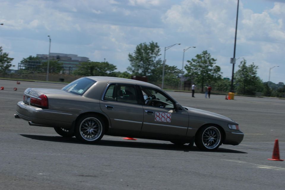 Gold Mercury Grand Marquis sedan with red 888 numbers on an autocross course
