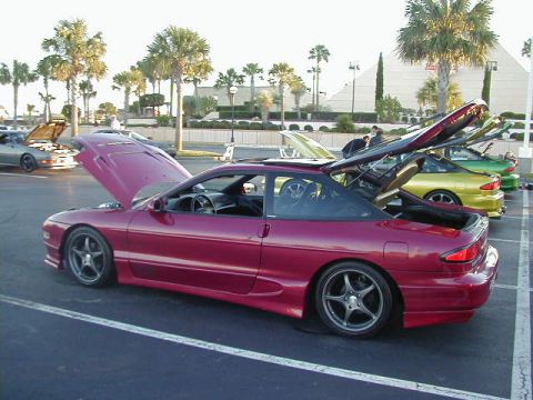 1994 Ford Probe - A maroon Ford Probe is parked with its hood and trunk open, alongside other cars.