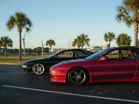 1994 Ford Probe - Two Ford Probes, one red and one black, are parked next to each other on a sunny day.