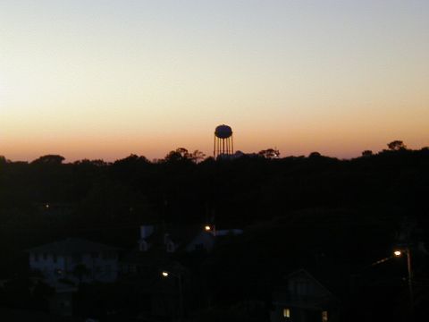 1994 Ford Probe - Water tower stands tall against the colorful sunset sky, with houses visible below.