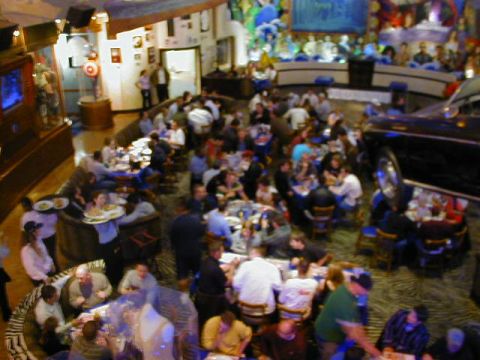 1994 Ford Probe - A busy restaurant scene with many patrons seated at tables, and a dark-colored car parked inside.