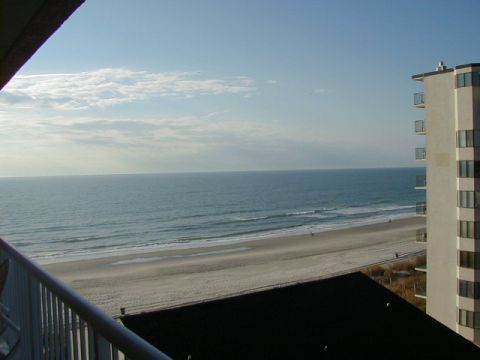 1994 Ford Probe - A view of the ocean and beach from a high vantage point, with a building visible on the right.