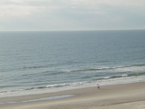 1994 Ford Probe - Ocean view from a beach with two people walking along the shore. Supermotors.net logo visible.